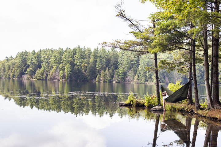 Man lies in hammock on a a lake