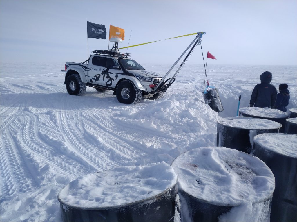 在沒有加油站的南極，長征隊把握時間趕到油料補給站將油桶從積雪中拉出來。