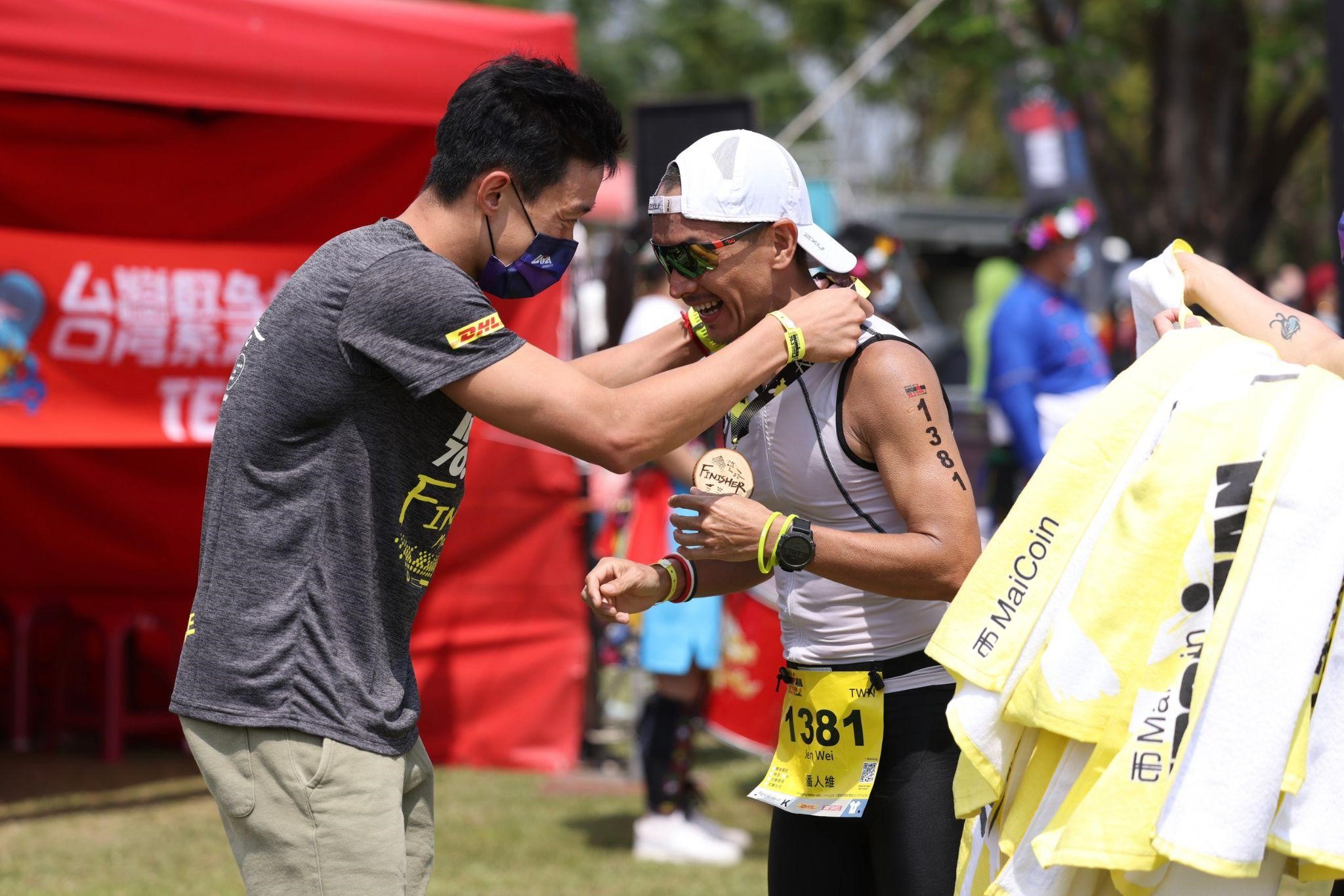 張團畯為 IRONMAN 70.3 台東站的選手們掛獎牌祝賀完賽