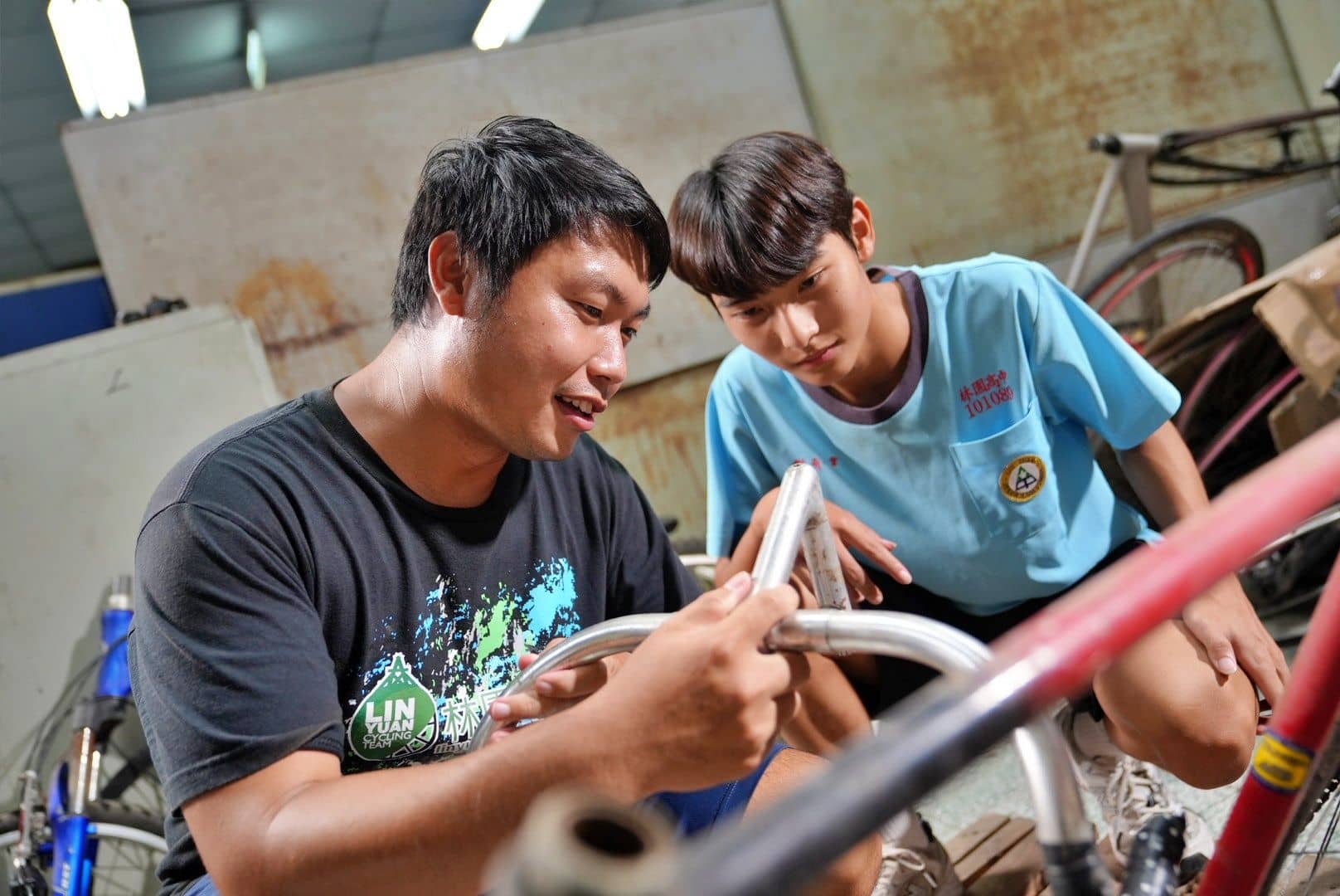 林園車隊黃晉隆教練（左) 指導同學老舊零件拆解過程中的注意事項