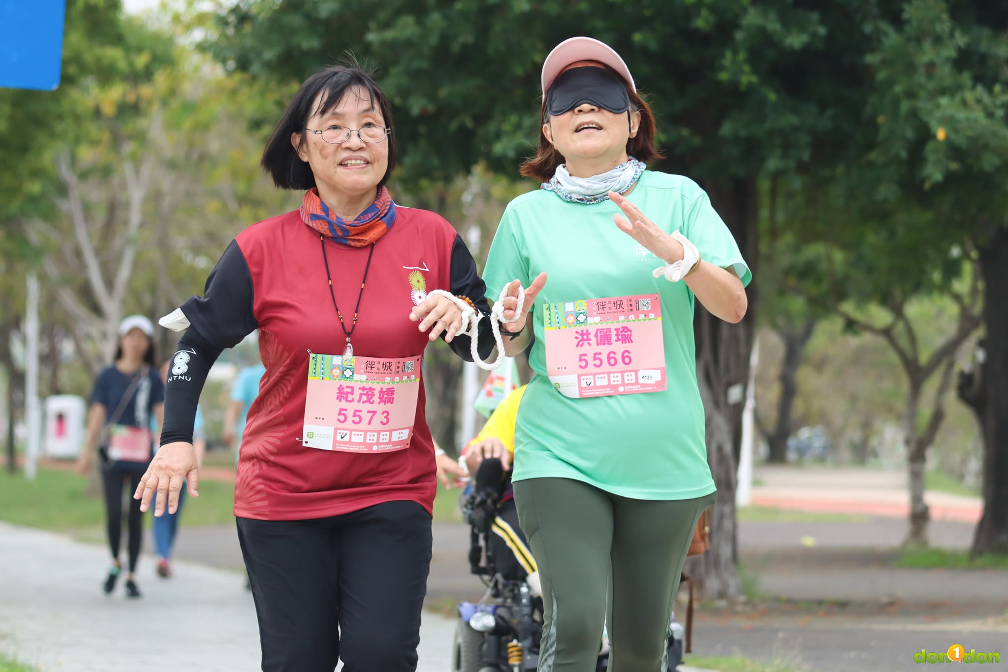 臺灣師大人事室主任紀茂嬌與臺灣師大特教系教授洪儷瑜體驗視障跑者與陪跑員