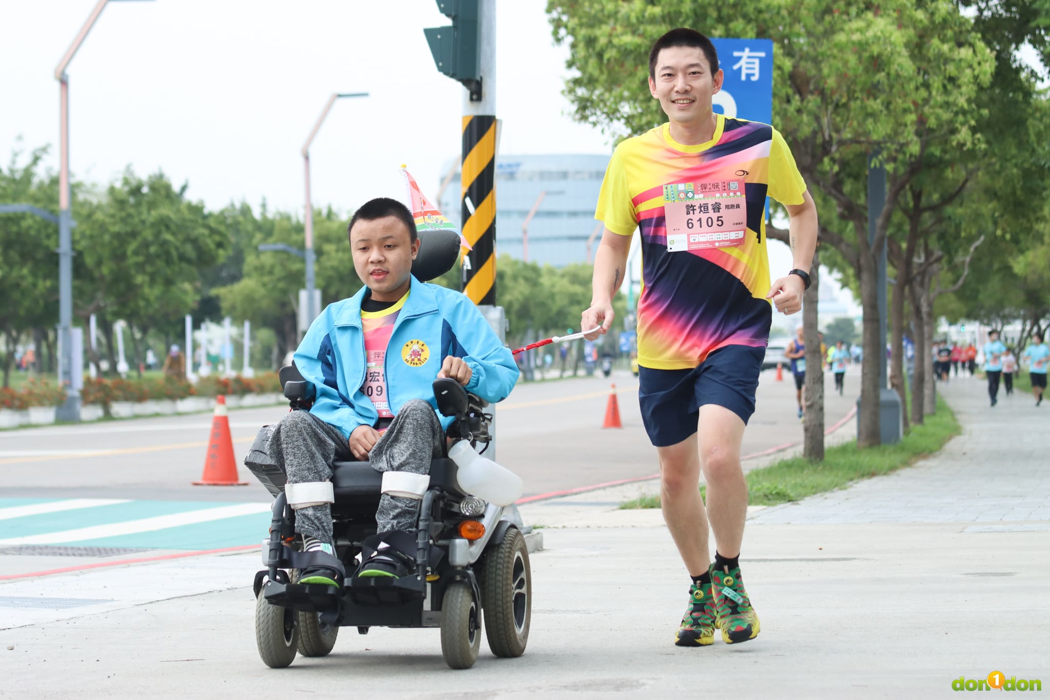 肢體障礙學生郭宏佑的陪跑員(左)，與屏東特殊教育學校老師許烜睿(右)