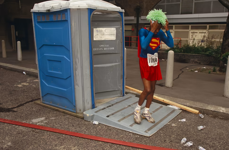 穿著超人裝的跑者從便利型廁所裡走出來 © Richard Baker / Corbis Historical / Getty Images