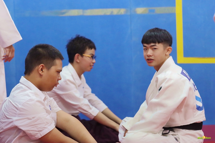 在課間過程中，柔道隊教練也會主動幫助啟明學生 (右：許竣凱)