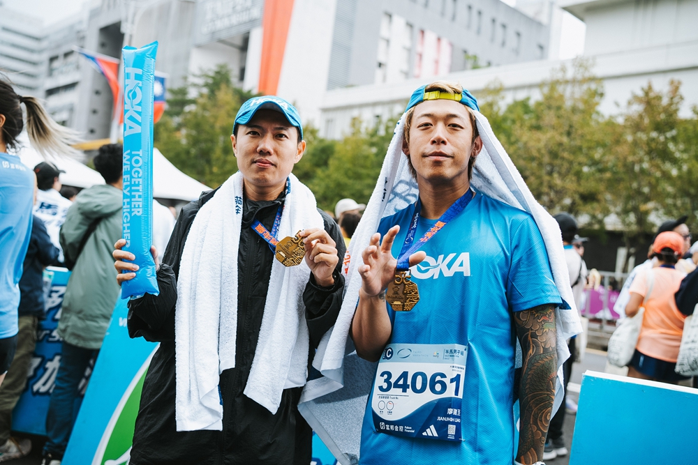 兩人在終點線後秀出完賽獎牌，正是「Together We Fly Higher」的最佳寫照