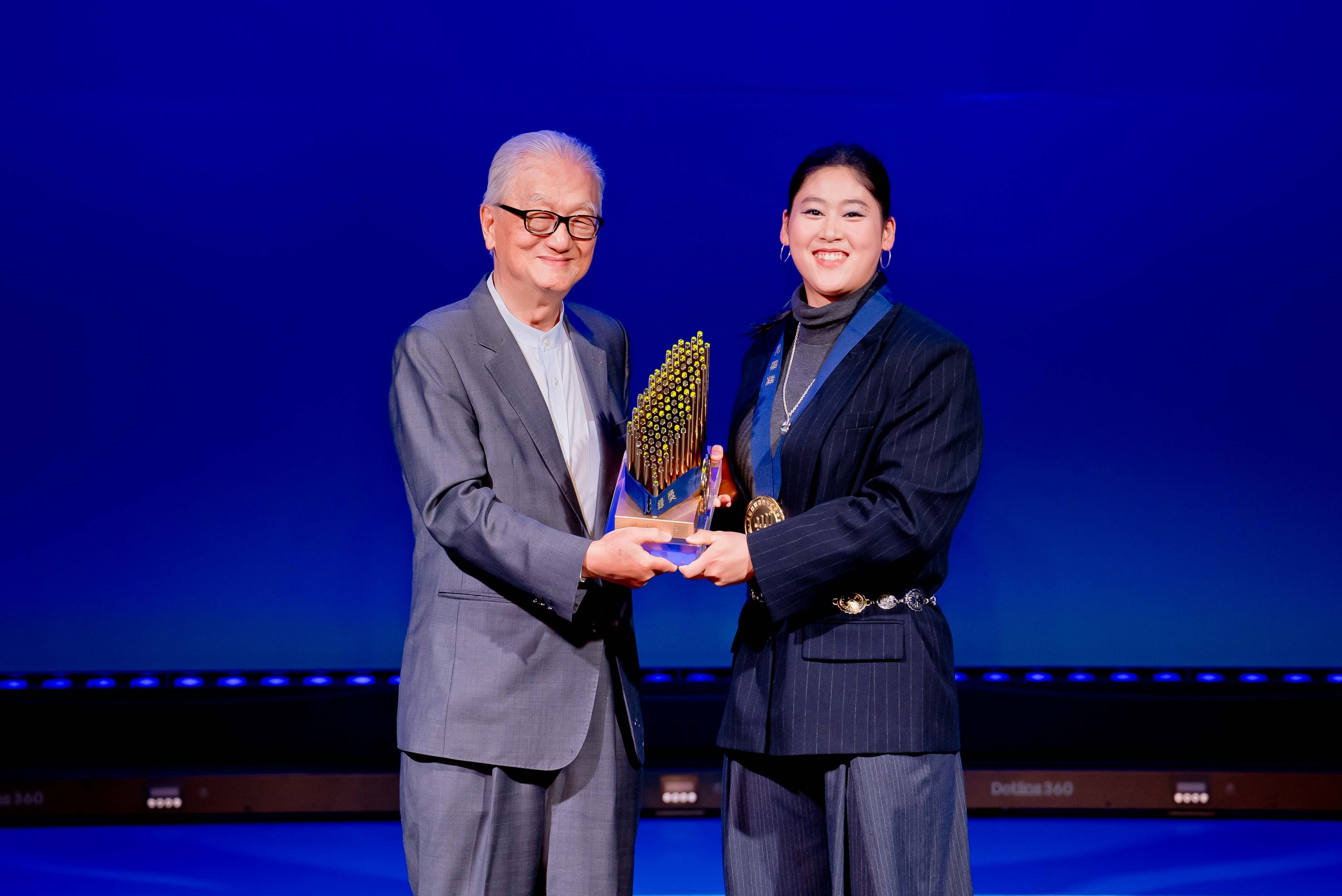 ▲大眾教育基金會創辦人簡明仁博士（左）將獎項頒予18 歲鉛球新星江靜緣（右）。